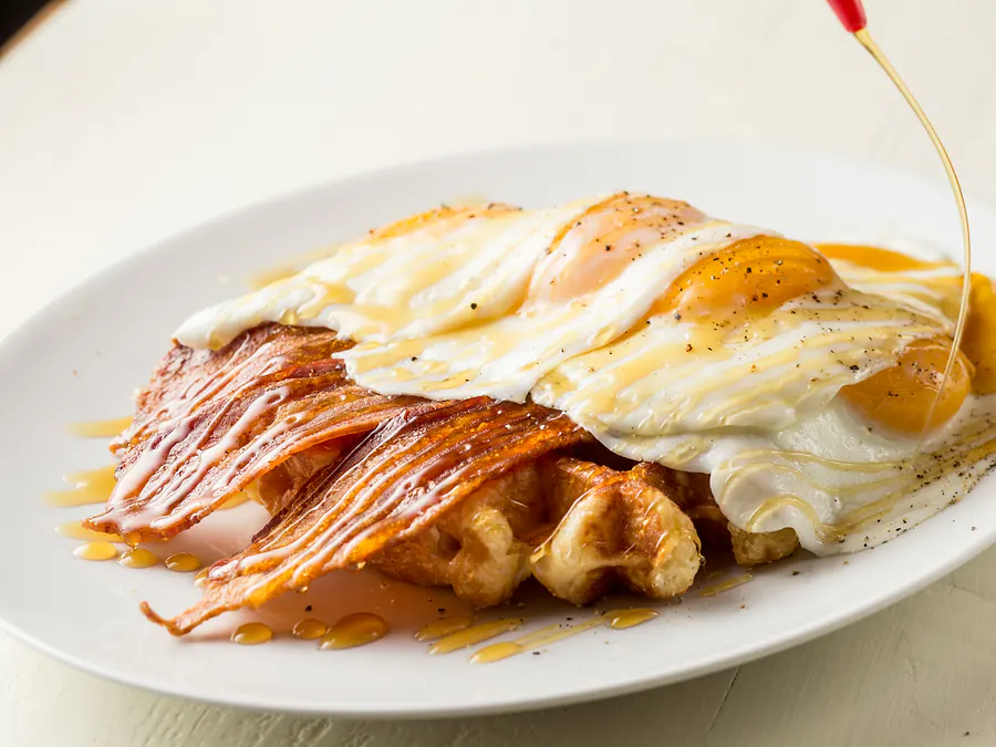 The Swanson — four eggs and four strips of bacon on a Liège waffle